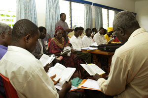 A training seminar in progress in Yaoundé on the Where Is the Good Samaritan Today? HIV/AIDS outreach package. Students are following in their copies of the booklet Where Is the Good Samaritan Today? while one reads aloud from it.