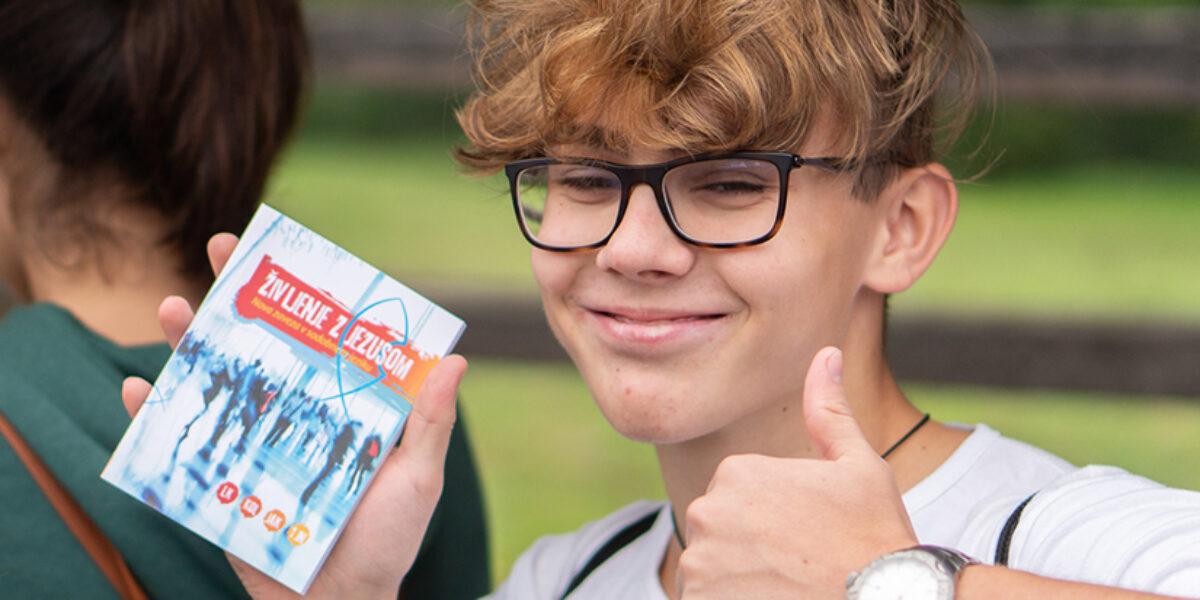Jernej, a 13-year-old Slovenia youth, receives a free copy of Life with Jesus during a youth festival in September (Photo Credit: Photo by Rok Pisk)