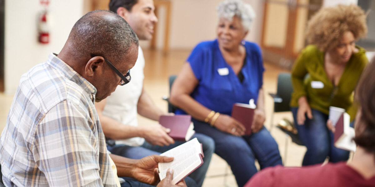 People Attending Bible Study Or Book Group Meeting In Community Center