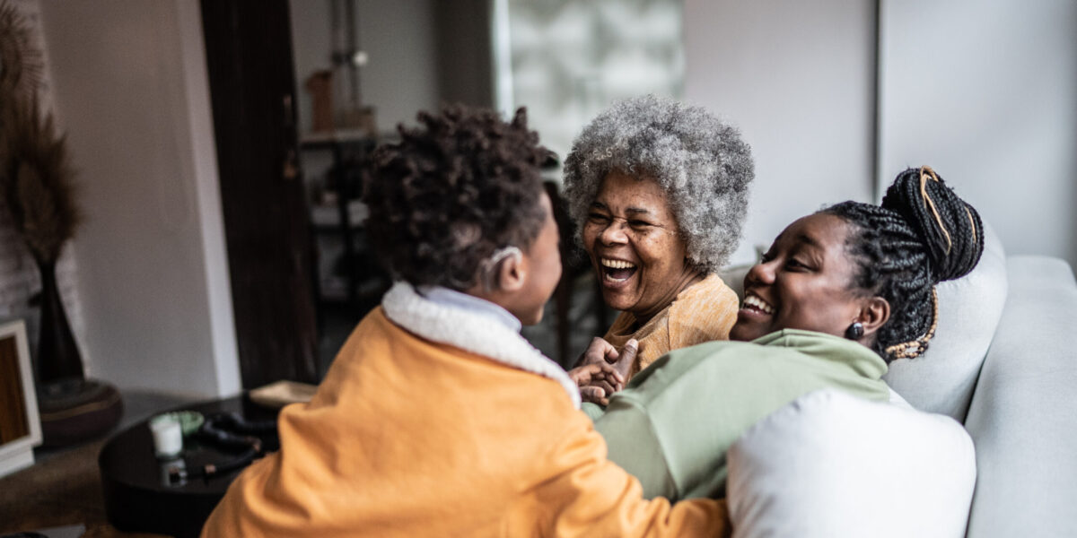 Child playing with his mother and grandmother in the living room at home