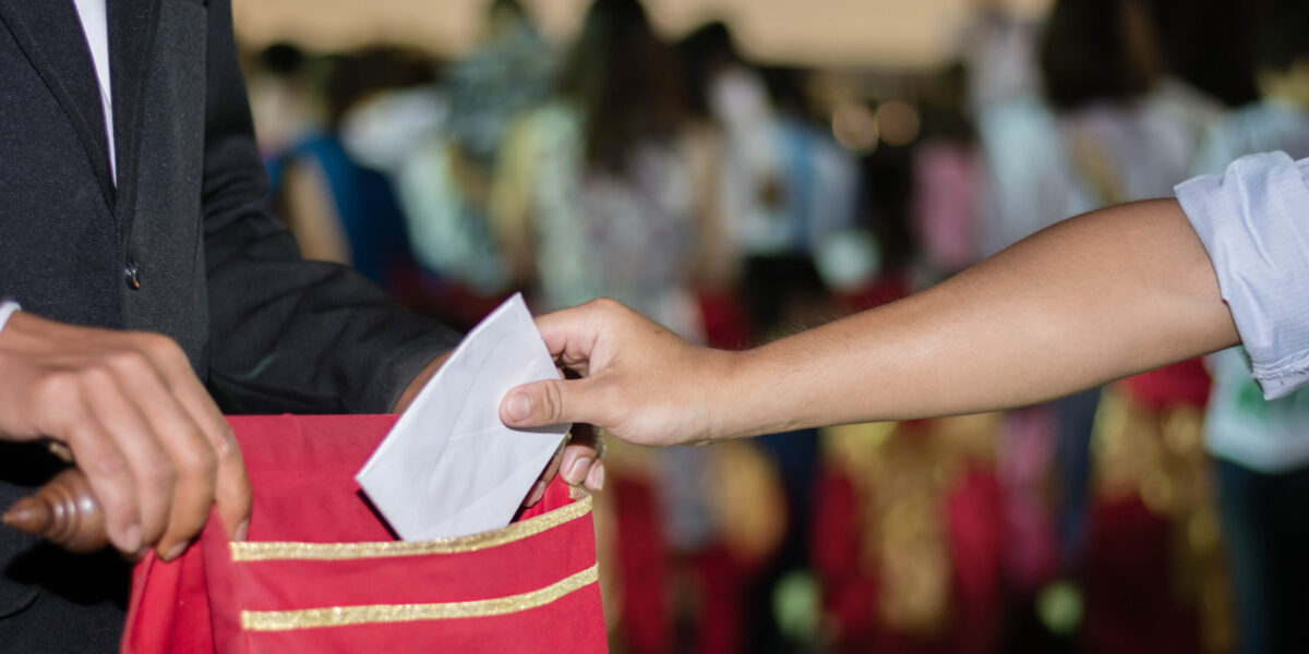 People,Putting,Tithing,Into,Velvet,Offering,Bag,In,Church