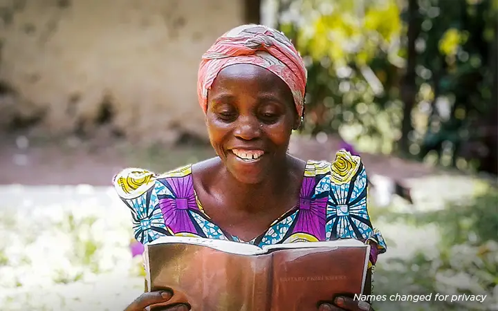 Woman reading her Bible while seated outdoors.